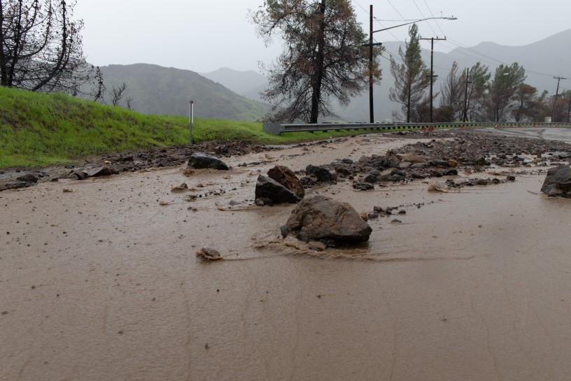 A thumbnail of mud and rocks on a highway after a mudslide down a hill which provides more information on the topic Wildfire impact 